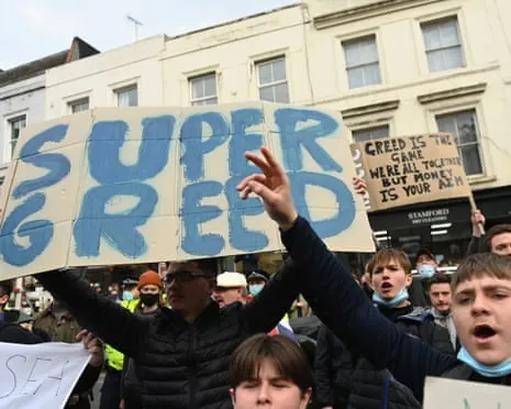 Fans protest with a sign that reads "Super Greed" during the 2021 protests against the European Super League.